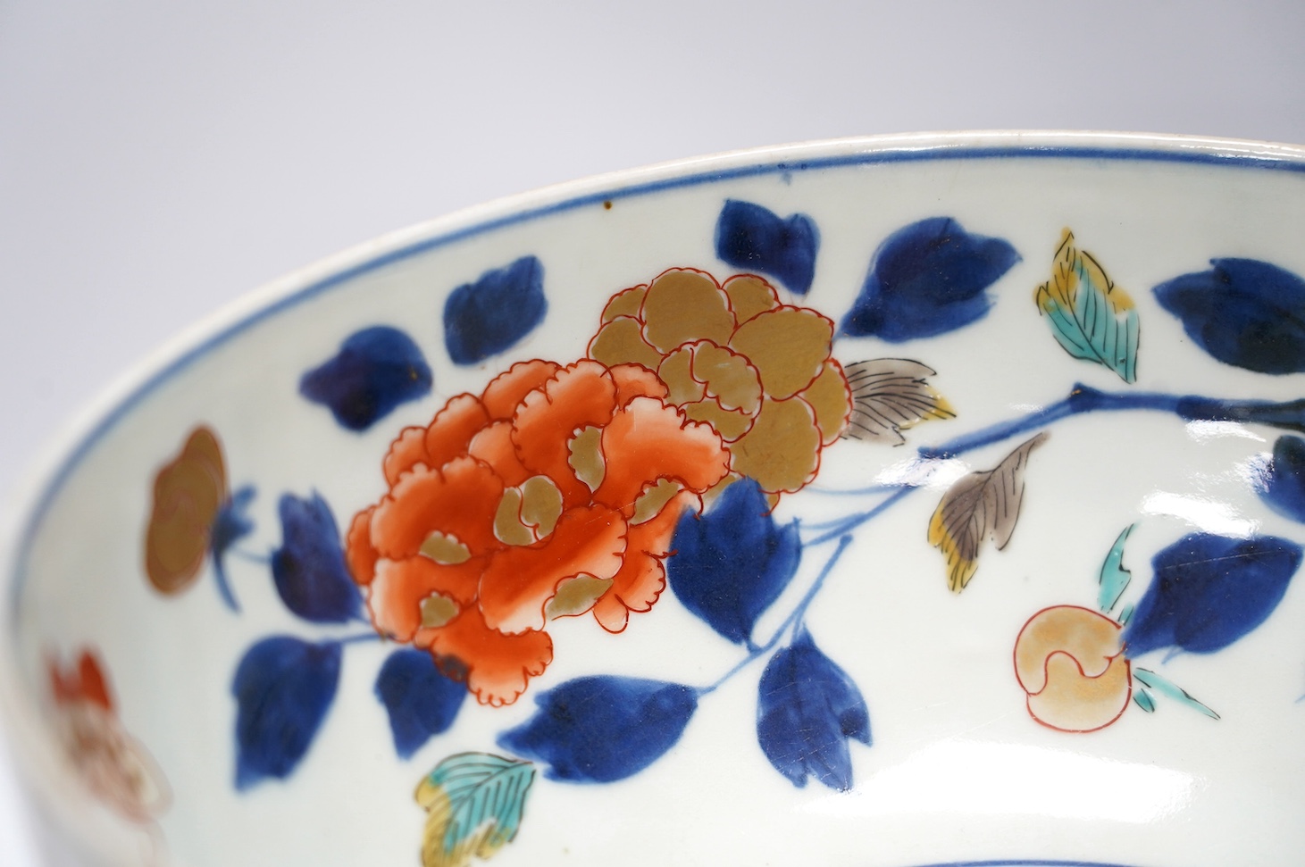 A Japanese Arita polychrome bowl, c.1700, diameter 24.5cm, height 12.5cm, on a carved hardwood stand. Condition - large overglazed open firing crack to foot, otherwise good
